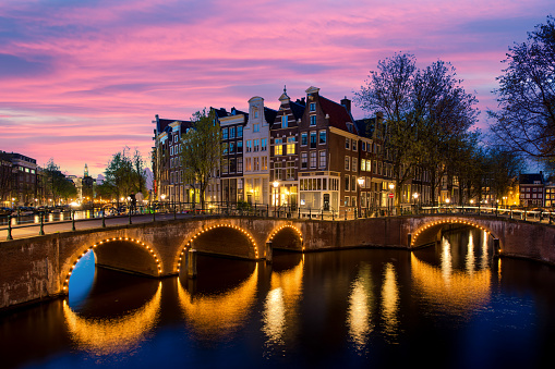 Night city view in Amsterdam, Netherlands. Canal and typical dutch houses at night in Amsterdam, Netherlands
