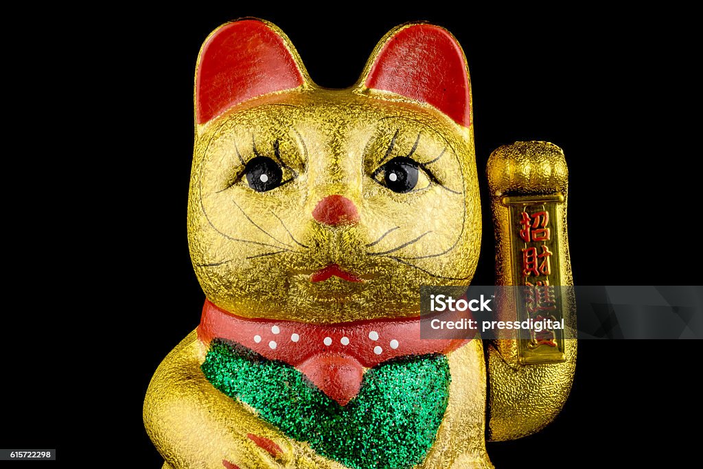 Beckoning Cat With Black Background Beckoning Cat, studio shot of golden asian figurine with black background Asia Stock Photo