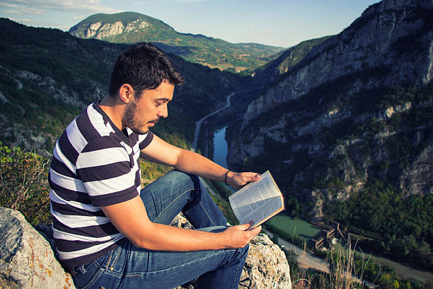 istock man relax on the hill and reading a book 615724448