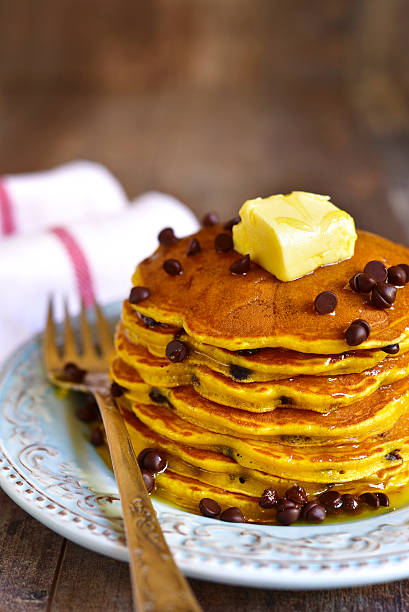 istock Pumpkin pancakes with chocolate drops on a rustic background. 615725584