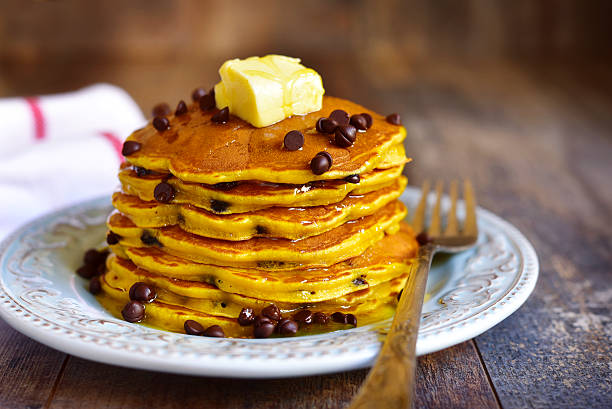 istock Pumpkin pancakes with chocolate drops on a rustic background. 615726610
