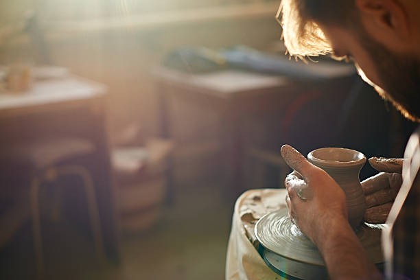 Potter at work Potter working with clay on wheel in studio pottery making stock pictures, royalty-free photos & images