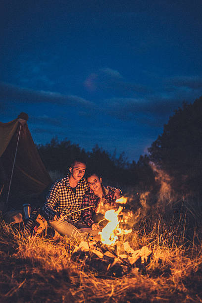 istock Couple preparing sausages on bonfire 615727476