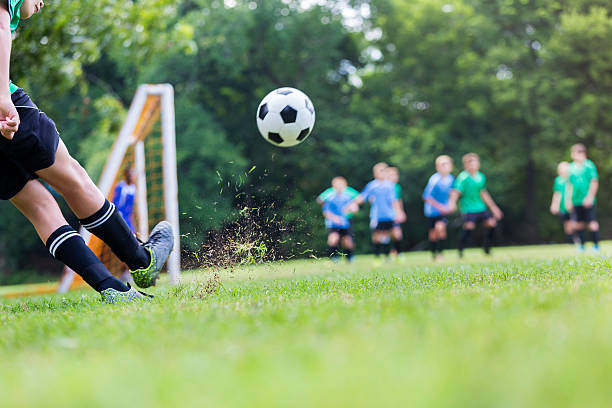 le ballon de soccer est dans les airs pendant que le joueur prend le coup - goalie soccer soccer player teenage boys photos et images de collection