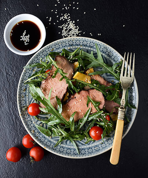 istock salad of arugula and roast beef on a black background 615731792