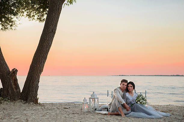 istock young couple on a beach at sunset 615734608