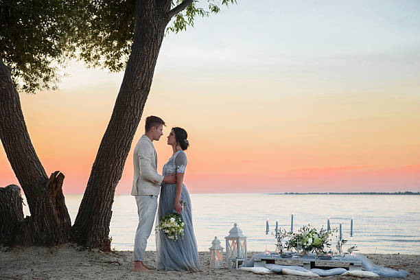 istock young couple on a beach at sunset 615734840