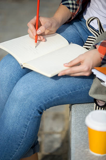 istock Student lady writing in an open notebook with a pencil 615734970