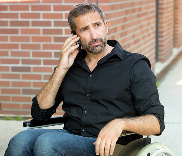istock man in wheelchair talking on his phone 615736446