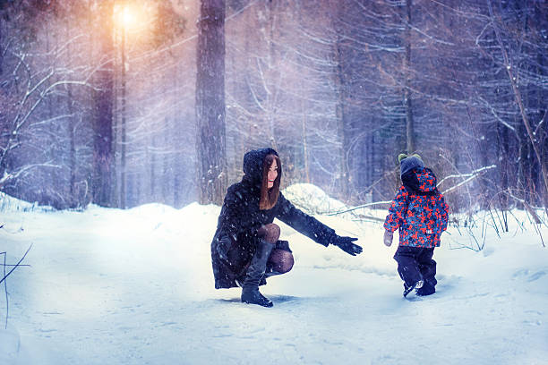 istock Mom and son in the winter forest 615737492