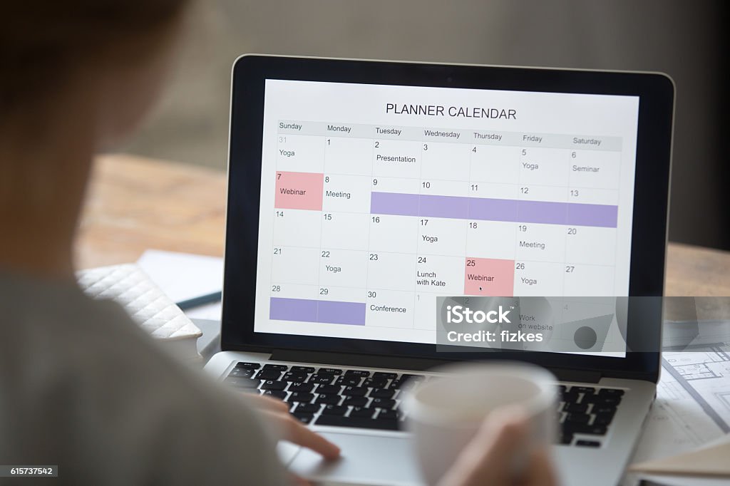 Abra la computadora portátil en el escritorio, el calendario del planificador en la pantalla - Foto de stock de Calendario libre de derechos