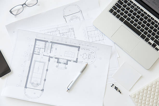 istock Top view of a working desk with an architect drawing 615737760