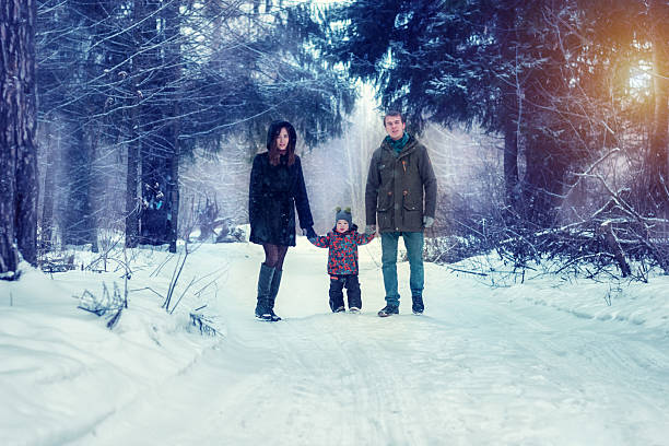 istock Mom dad and son in the winter forest 615737858