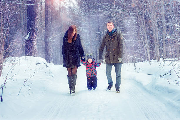istock Mom dad and son in the winter forest 615738196