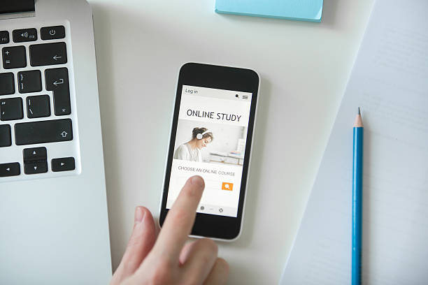 istock White office desk with a hand touching a mobile phone 615738674