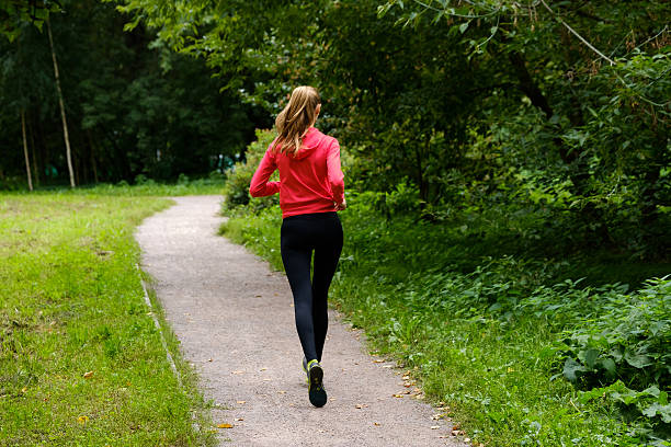 istock Young woman jogging in the park 615742702
