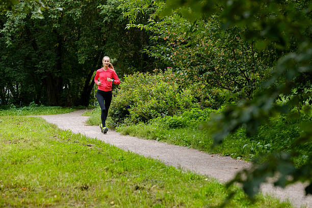 istock Young woman jogging in the park 615742762