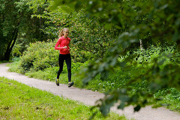 istock Young woman jogging in the park 615742830