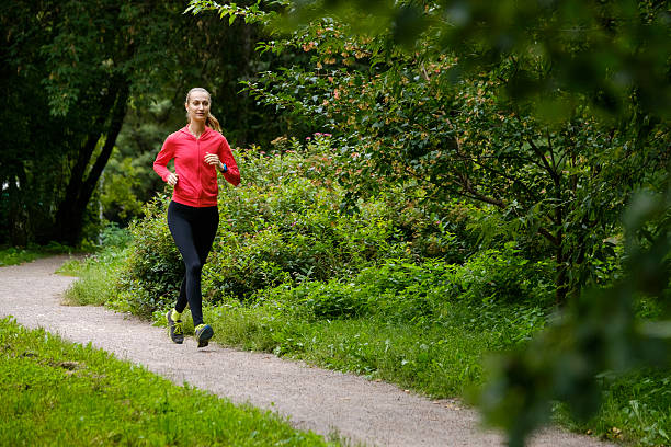 istock Young woman jogging in the park 615742878
