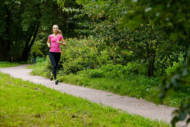 istock Young woman jogging in the park 615742944