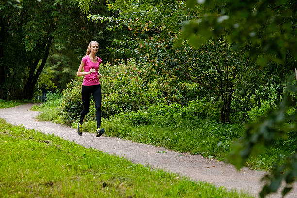 istock Young woman jogging in the park 615743038