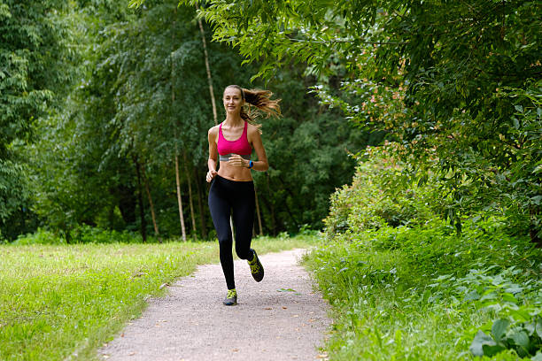 istock Young woman jogging in the park 615743268