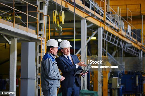 Man In A Suit And A Worker In Overalls Stock Photo - Download Image Now - Office, Engineer, Factory