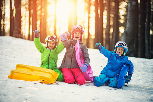 Niños felices con toboganes disfrutando del invierno photo