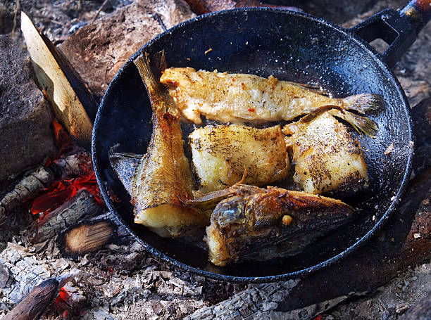 istock Fried fish on the fire in a skillet. 615744968
