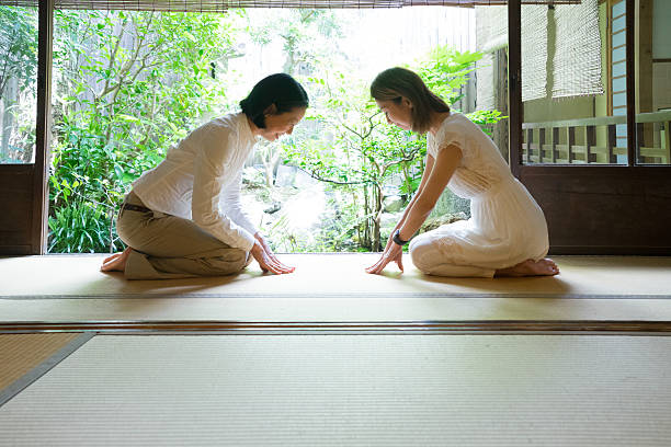 Two Japanese women bowing with respect Two Japanese women bowing with respect in a traditional house. curtseying stock pictures, royalty-free photos & images