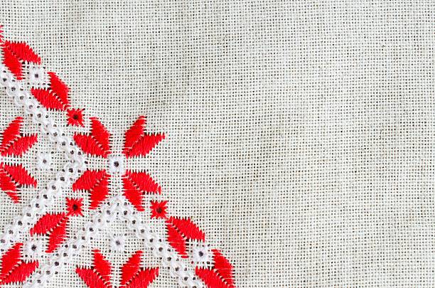 Element handmade embroidery on flax by red and white cotton threads. Design of ethnic textures. Background with embroidery. Geometric ornament.
