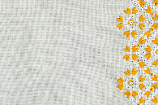 Embroidered fragment on flax by yellow and white cotton threads.