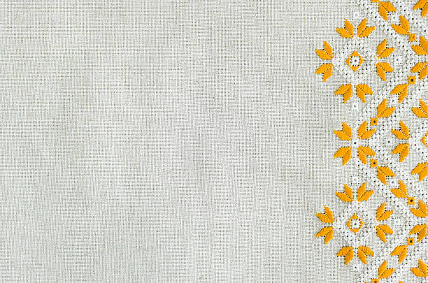 Embroidered fragment on flax by yellow and white cotton threads. Embroidered fragment on flax by yellow and white cotton threads. Macro embroidery texture flat stitch. Geometric ornament. sewing item photos stock pictures, royalty-free photos & images