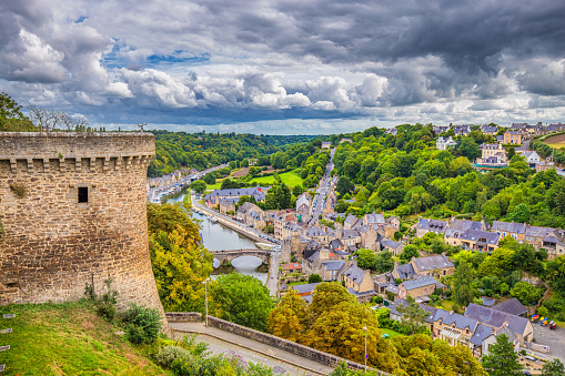 Aerial view of the historic town of Dinan with Rance river with dramatic cloudscape, Cotes-d'Armor department, Bretagne, northwestern France.
