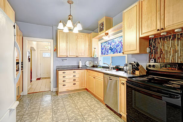 istock Kitchen interior with golden cabinets, black and white appliances 615748672