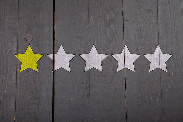 istock One yellow ranking star on black wooden background 615749080