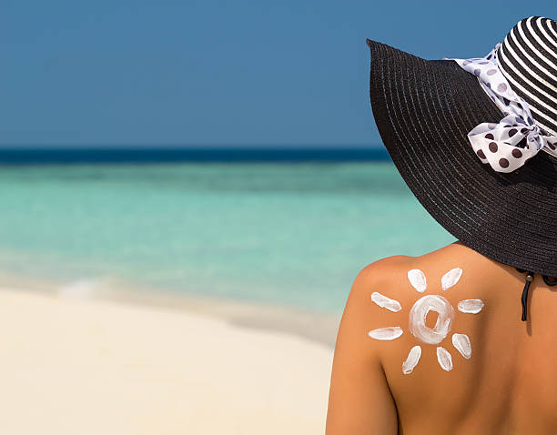 Woman with sun-shaped sun cream Woman with sun-shaped sun cream suntan lotion photos stock pictures, royalty-free photos & images