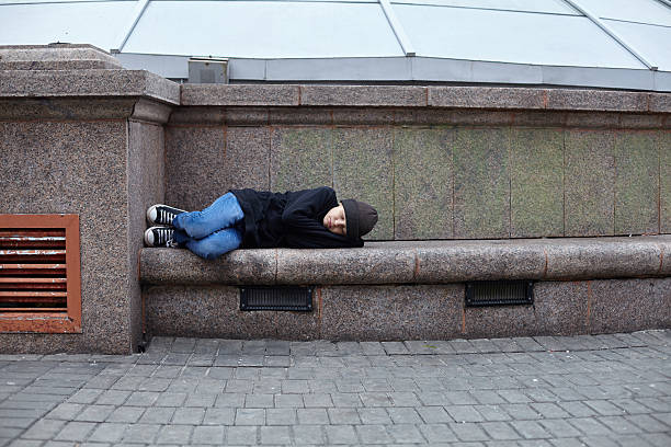 istock young homeless boy sleeping on the street 615793322