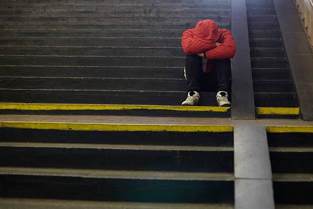 young homeless man sleeping on the street, poverty, city