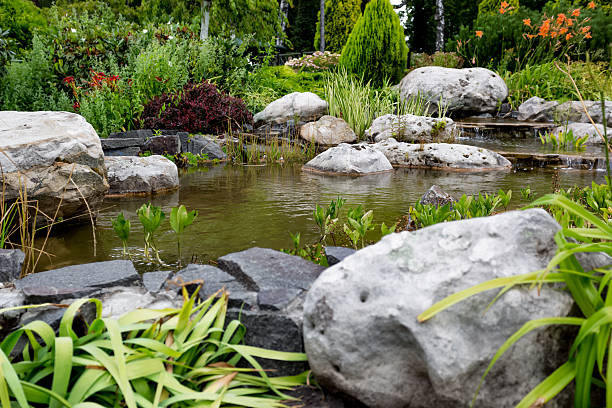 istock Water flowing through rocks in formal garden 615794216