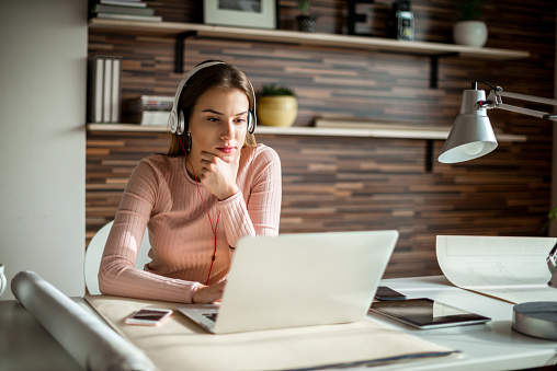 Woman enjoying some music while working in the office.