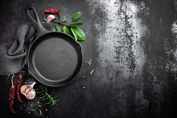 istock cast iron pan and spices on black metal culinary background 615795794