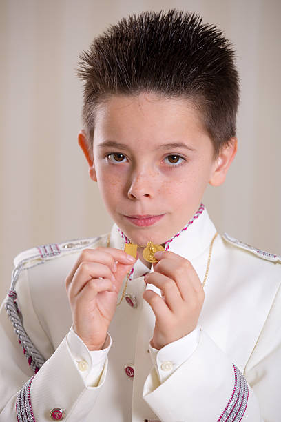 istock Young boy showing his medals in his First Holy Communion 615795878