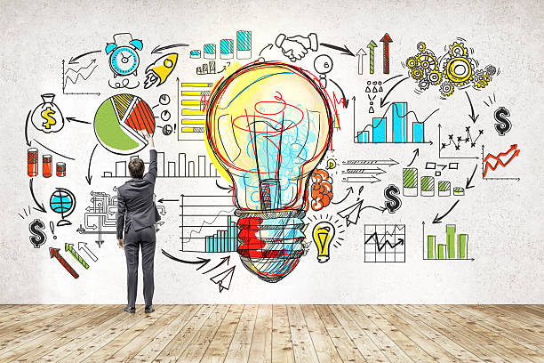 Businessman near blackboard with startup sketch Rear view of businessman in suit drawing colorful startup sketch. Large light bulb icon in center. Concept of successful startupper market research photos stock pictures, royalty-free photos & images