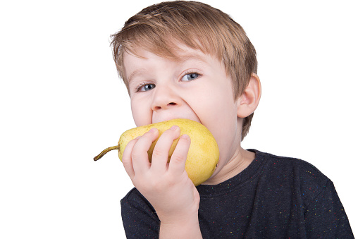 Close-Up Image Of Small Boy Eating Pear.