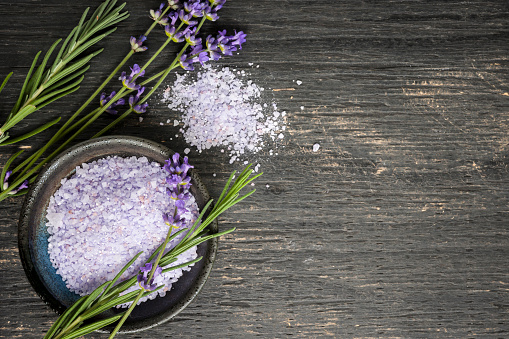 Bath salts herbal body care product with fresh lavender on rustic wooden background, copy space