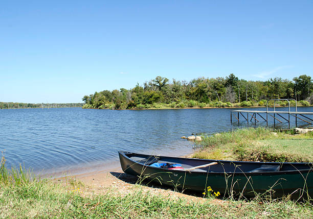 istock Green Canoe On The Lake Shore 615803458