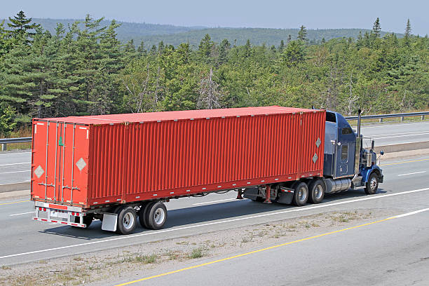 istock Semi Tractor Trailer Truck Hauling A Large Shipping Container 615804022