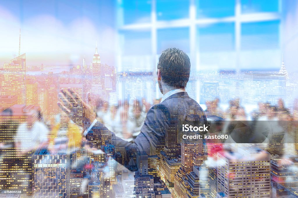 Speaker giving talk at Business Conference. Business meeting. Rear view of Speaker at Business Conference. Public Presentation. Audience at the conference hall. New Your city lights reflection in window. Public Speaker Stock Photo