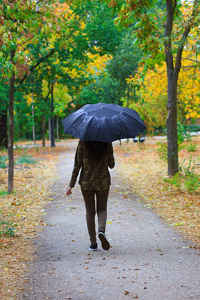 istock Girl walking in a forest a rainy day. 615804462